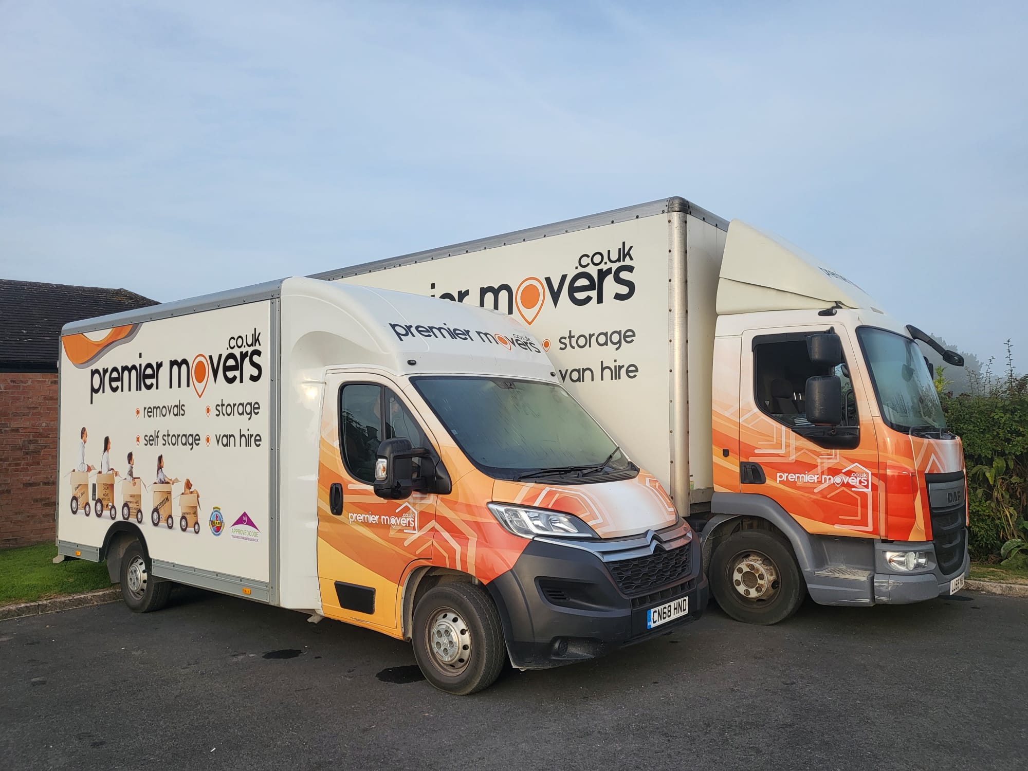 image of a large and a medium sized lorry with the premier movers signage on the side